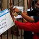 FILE PHOTO: Health workers attach a notice on the shortage of COVID-19 vaccine supplies at a vaccination centre in Mumbai